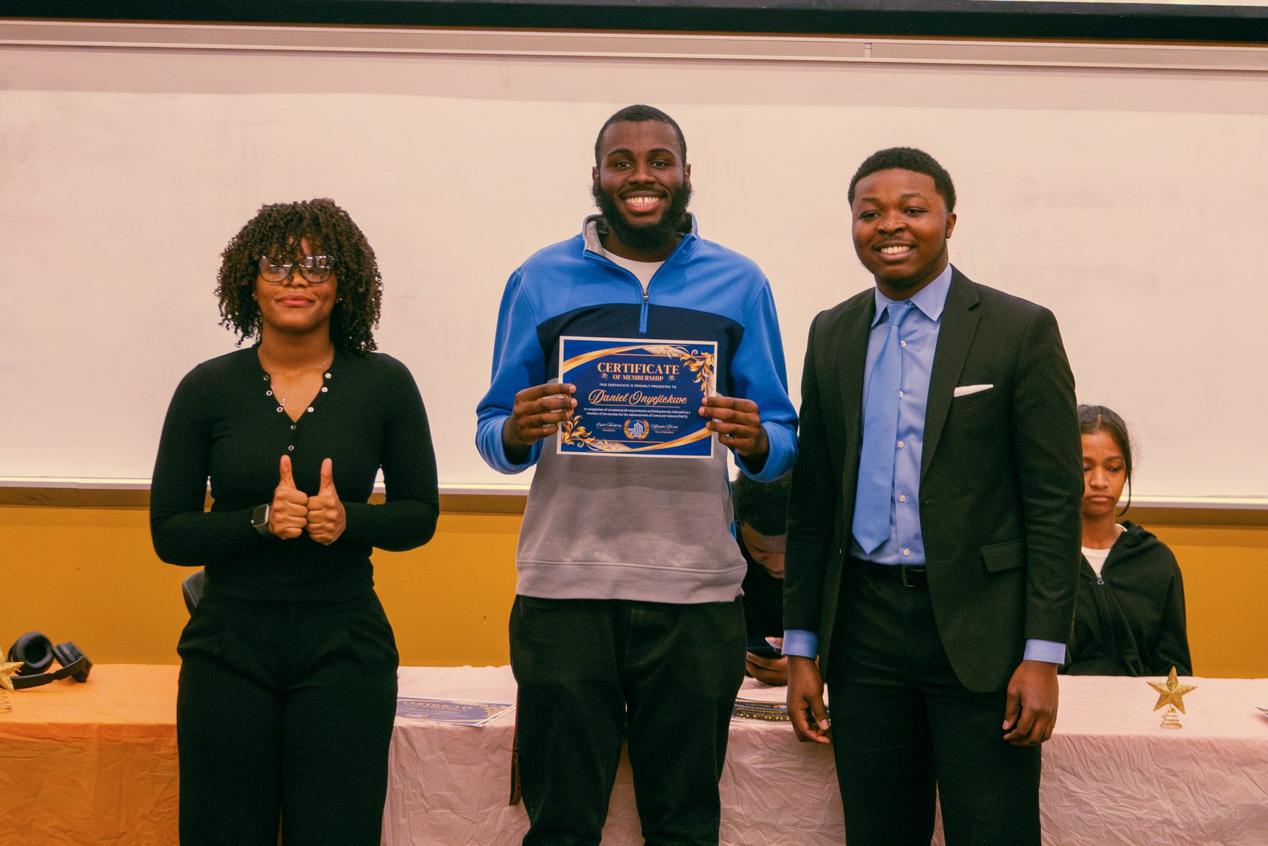 Daniel Onyejiekwe holding his SACS certificate of membership